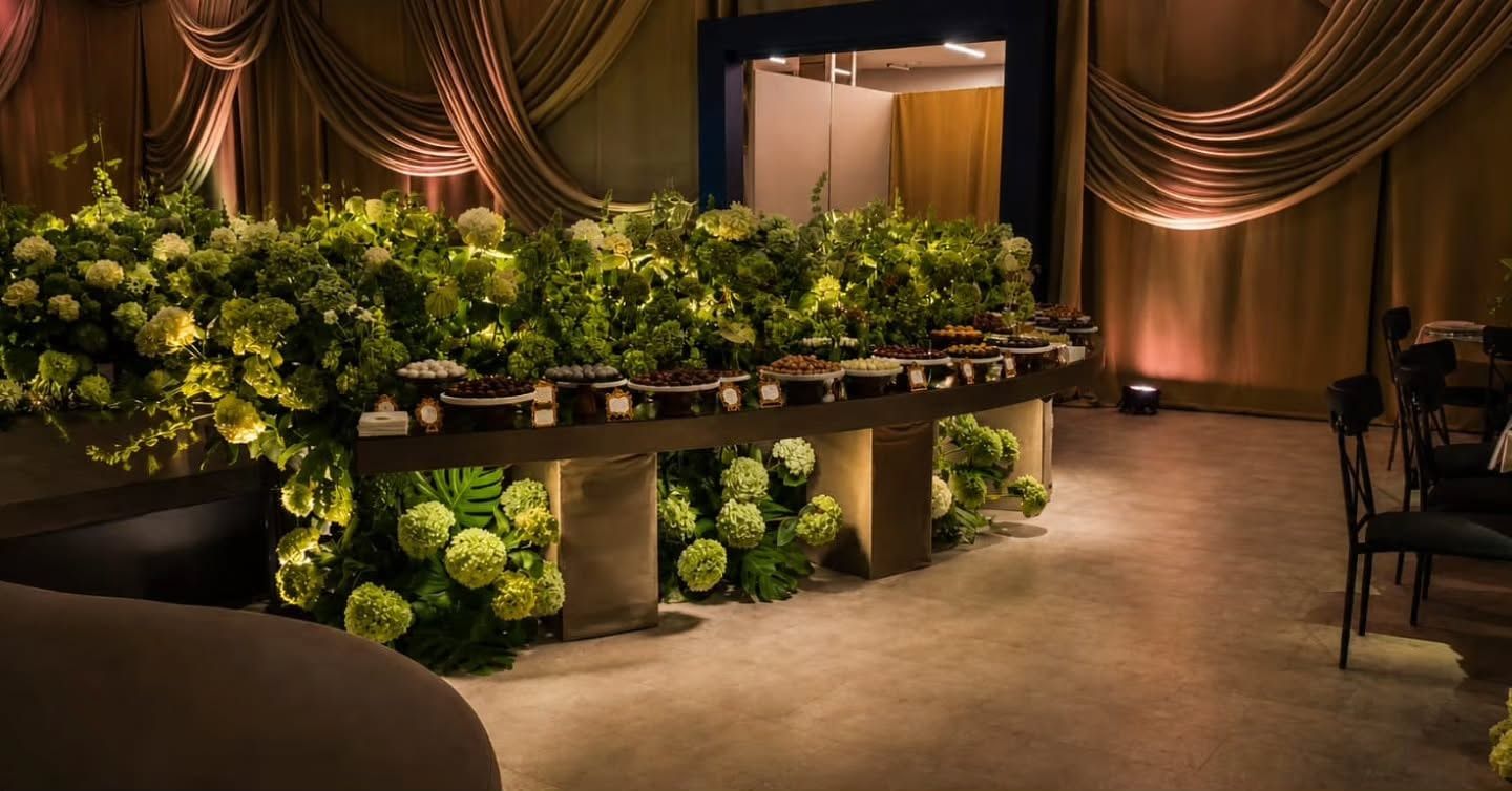 Mesa de postres semicircular rodeada de hortensias verdes