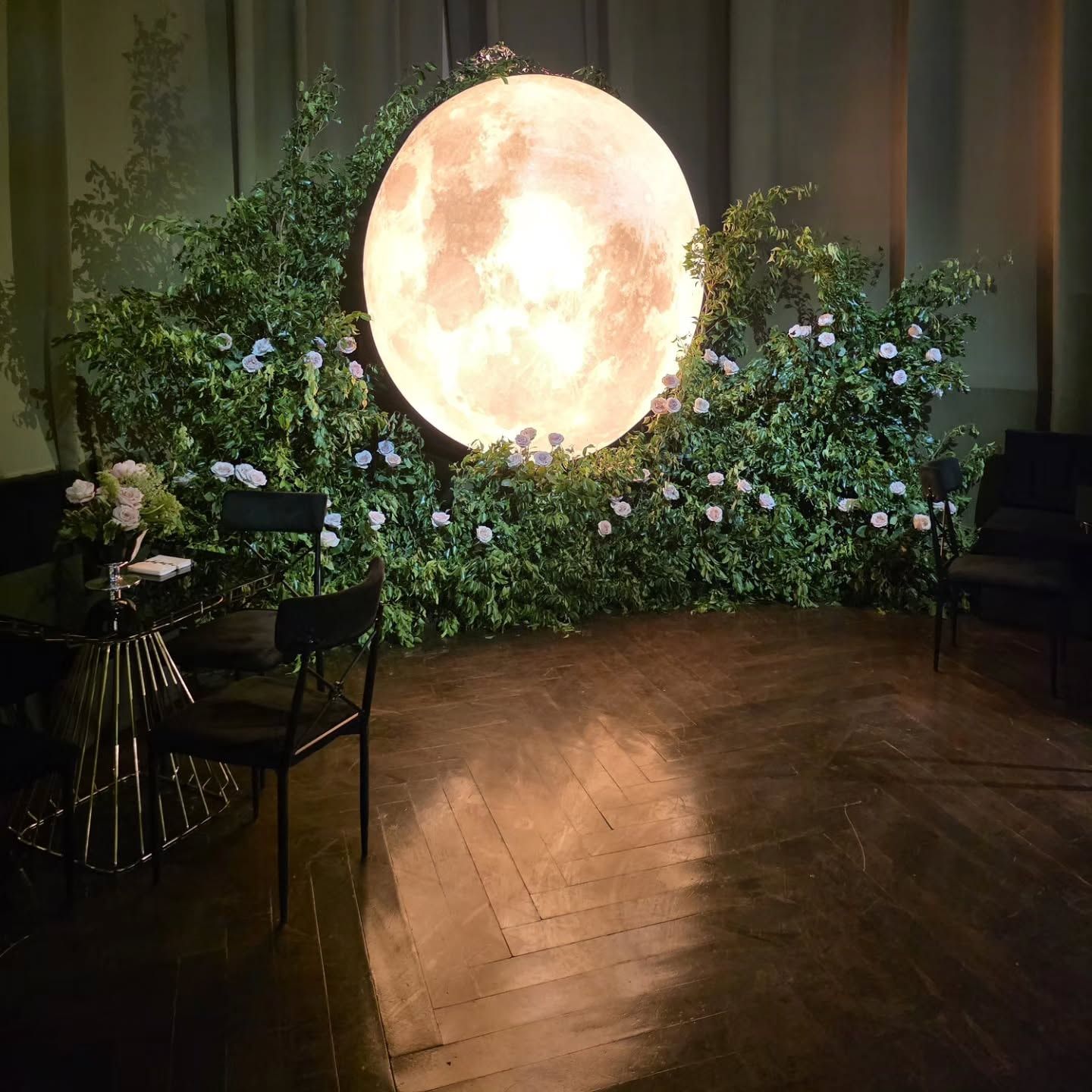 Luna iluminada sobre un muro de follaje